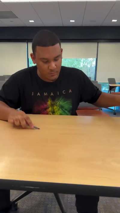 Guy drumming pens on a desk.