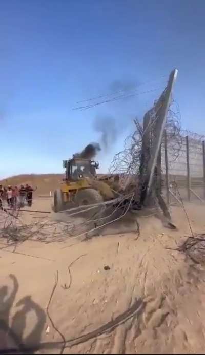 Palestinians tearing down Israeli fence which kept them inside Gaza