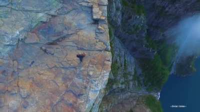 sitting athe the edge of this huge cliff in norway
