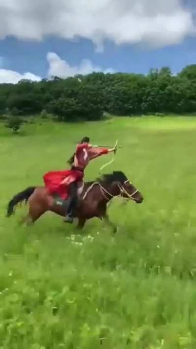 Archer shooting 3 targets, while riding a horse