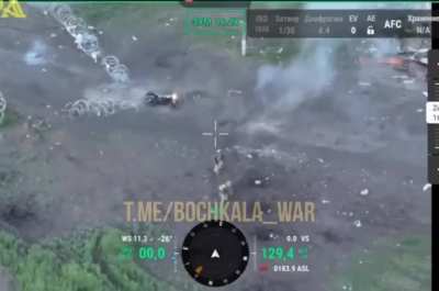 Drone footage of two Russian soldiers trying to break through Ukrainian barbed wire with their motorcycle.