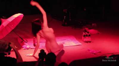 Glittery dancer in a C-string shaking her tassels