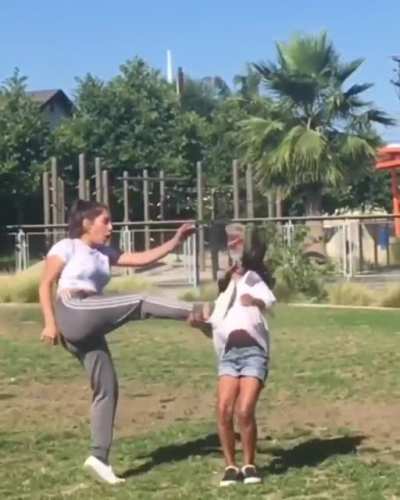 Attempting to kick a cup off her friends head