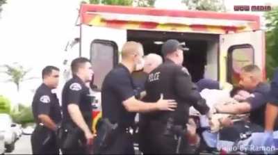 LAPD officer punches young man who is handcuffed to an ambulance gurney for calling him a bitch.