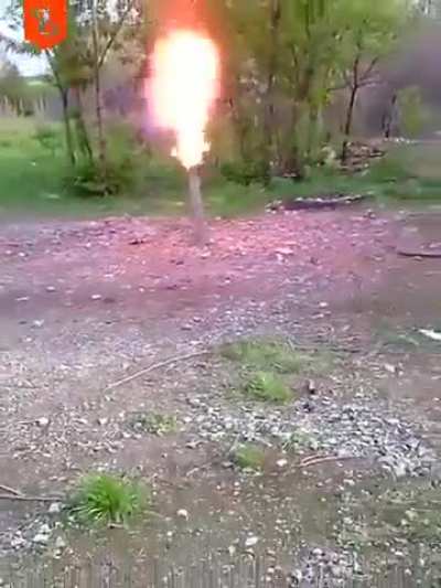 Man pits a lit cigarette into a tube and it bursts into flames