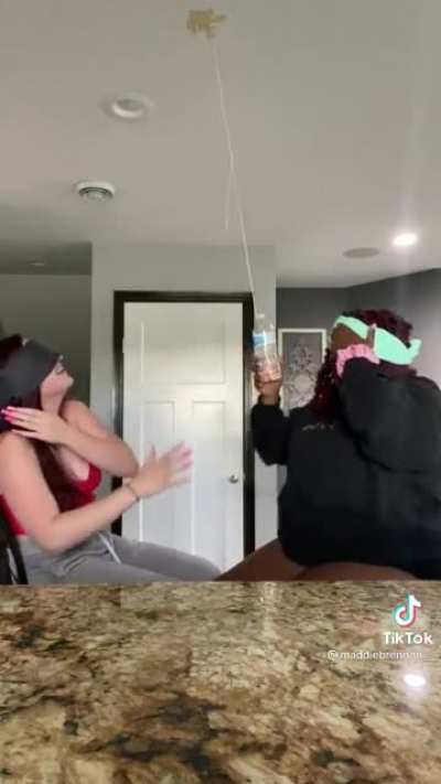 Two girls avoiding a water bottle
