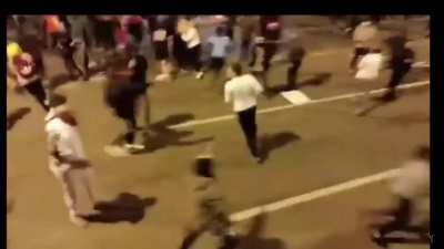 Man gets jumped by a bunch of rioters after telling them to stop breaking windows of a business. While getting beaten by the mob in fear of his life, he takes out a gun and fires a shot in the air which ultimately disperses the mob and has them running in