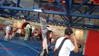 Neckbeard harasses cosplayer with a sign for sayin the truth.