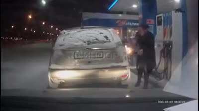 Using a lighter to see the gas pump nozzle