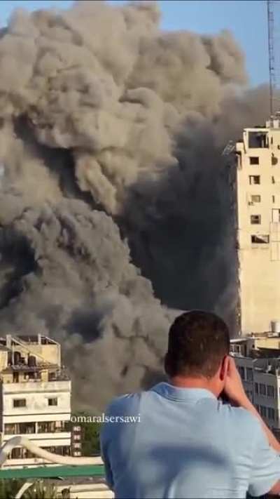 Journalist standing still capturing israeli missiles hitting a building in Gaza