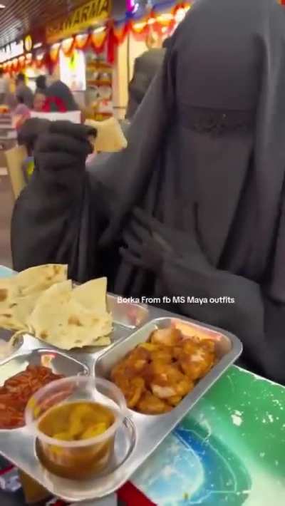Muslim woman shows how to eat in public with a customized burqa/niqab