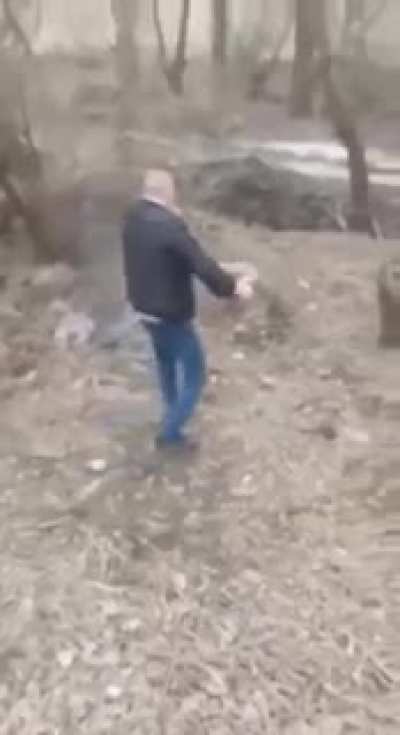 Carrying a landmine by hand with cigarette in mouth