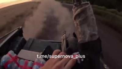 GoPro view of Russian soldier in back of speeding tactical golf cart firing rifle at pursuing FPV drone (which nearly hits them)
