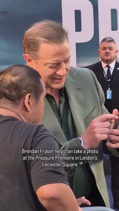 Brendan Fraser patiently helps a fan trying to take a photo with him