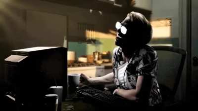 Guy with glasses sipping coffee logging onto computer shocked at text