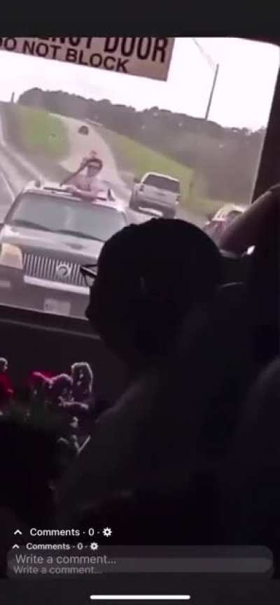 Idiot hanging out of sunroof pulls a gun on a school bus. Local authorities are investigating and searching for the suspect(s).