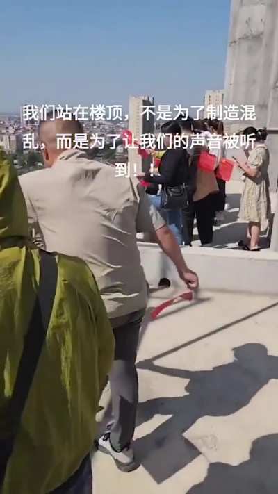 9月23日<wbr>，湖南常德<wbr>。碧桂园·<wbr>豪园楼盘烂<wbr>尾，业主们<wbr>站在楼顶边<wbr>缘挥舞国旗<wbr>维权。