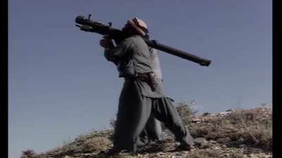 A Mujahideen fighter fails to lock his SA-7 on a Soviet Mi-24 helicopter that just arrived to protect an Afghan Army fort from enemy fire, c. 1984