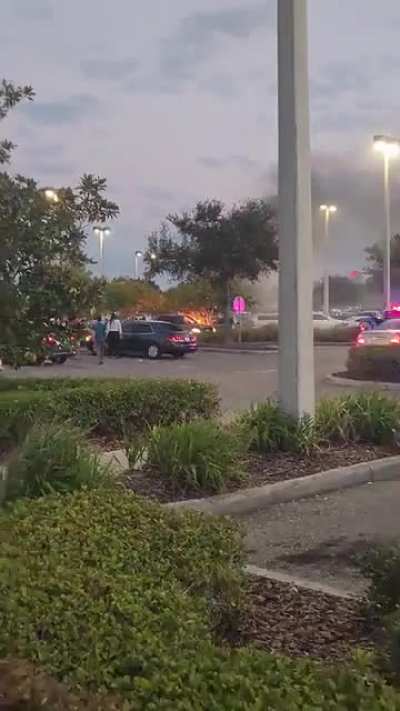 Car on fire in parking lot.
