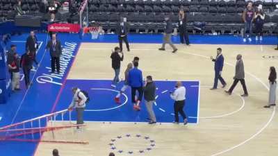 Wells Fargo center crew working on rims after the game and Giannis pushes down ladder to practice FTs