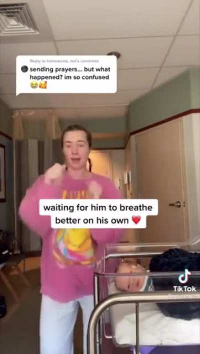 Woman dances next to her sick baby.