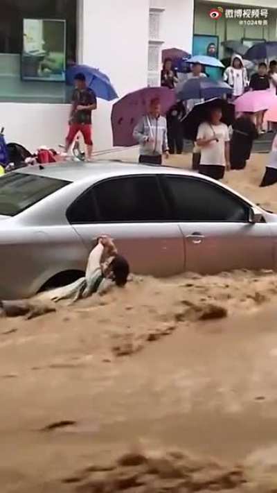 Woman stranded in middle of flooded street, gets washed away by flood