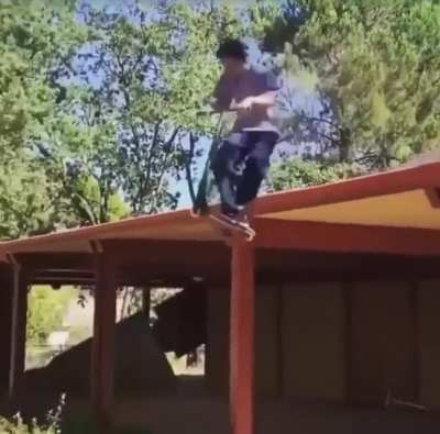 Boy gets a surprise uppercut from his scooter as rides off the roof of a building
