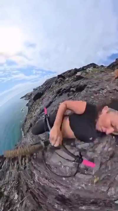 Riding a bike along an extremely narrow cliffside path.