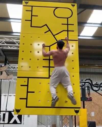 The absolute core strength of this guy climbing the wall with sliding holds