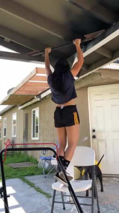 Good boy helping his human by placing chair under her feet.