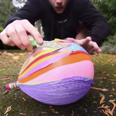 Shaky-handed man pops many balloons