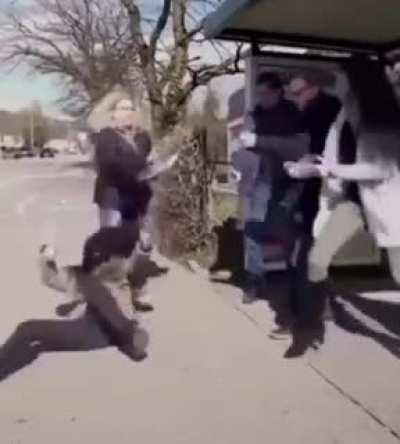 A woman sneezes at a bus stop