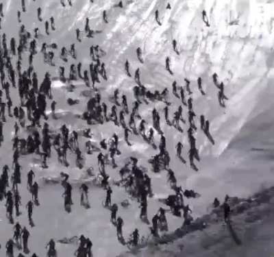 Hundreds of riders hurtle down an icy cliff and crash into one another as 