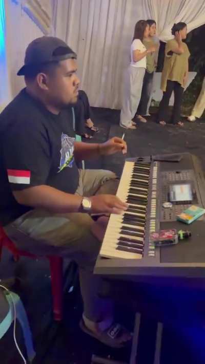 Indonesian keyboard player casually running an entire dance party by himself