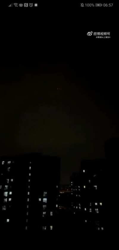 Shanghai residents go to their balconies to sing and protest lack of supplies. A drone appears: 