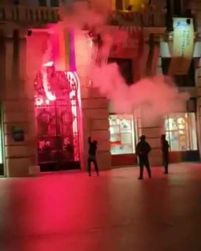 Homophobes burning a LGBT flag in a public square.