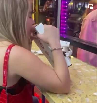 Woman calmly eats a pizza box.