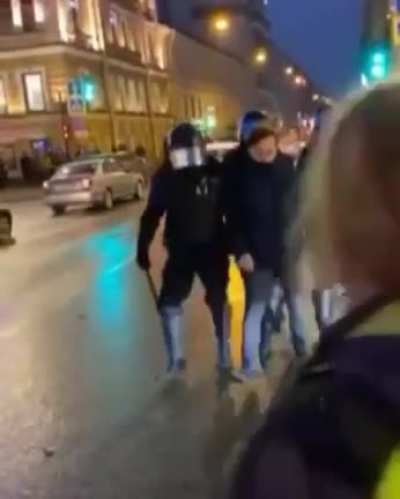 Russian policeman kicking old woman