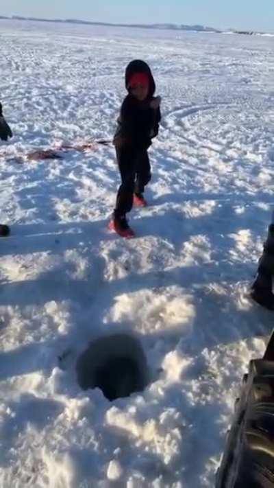 Boy catches fish the same size as himself.