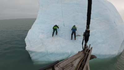 Idiots climb an iceberg which flips over.