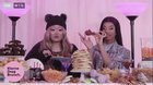 Naomi putting the chicken between her teeth but not taking a bite.