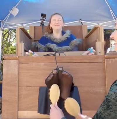 Letting your feet be tickled in a public place