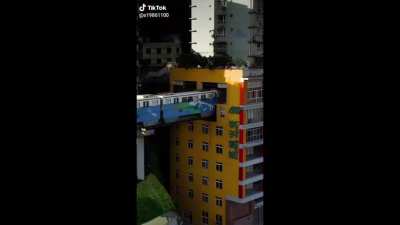 Train going through an apartment biulding