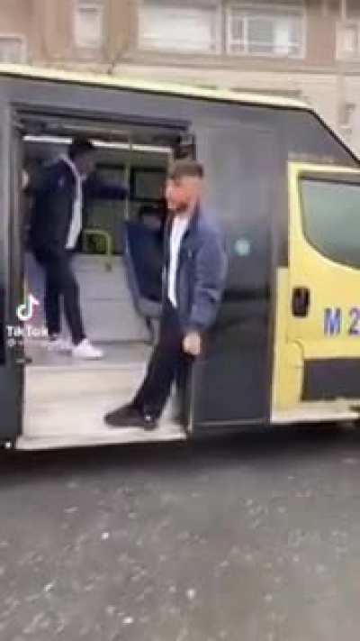 Hanging from the door of a bus