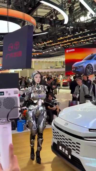 Yes, this is a real human inside a robotic suit, and it’s insanely realistic. She’s been blowing people’s minds at recent tech expos in China, and no matter how much I dig, I can’t find who the performer actually is. Anyone know?
