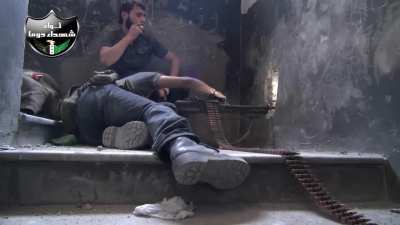 FSA fighter works to get an angle while firing his PKM out of a loophole cut overlooking al-Mutahleq al-Janoubi Highway - Qaboun, Damascus - 2013