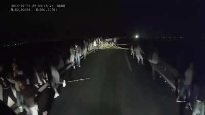 Migranți pașnici urându-le șoferilor de tir 