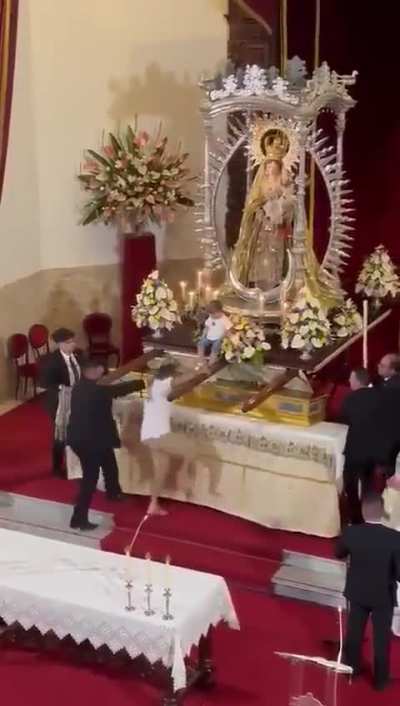 Man in Spain runs to put child on Madonna statue right before Mass