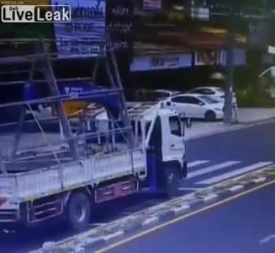 Taiwanese workers try to ease under power lines then exit vehicle, unaware they have already made contact and the back wheels are arcing to the ground.