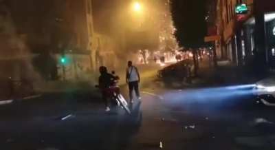 A guy makes a little jump to avoid getting hit by a chainsaw dragged by a motorcycle.
